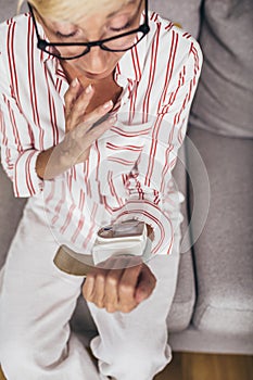 Woman measuring blood pressure at home