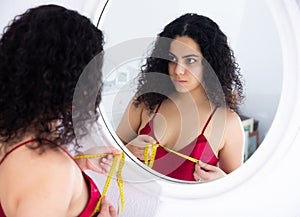 Woman measuring bust size using tape measure