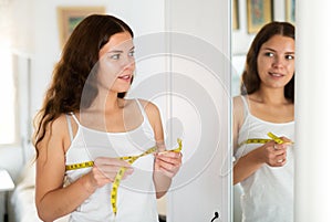 Woman measuring bust size using tape measure