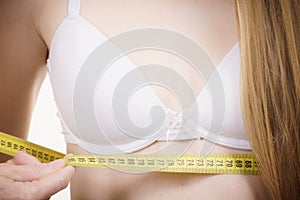 Woman measuring girl under breast