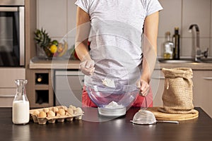 Woman measuring and grabbing flour