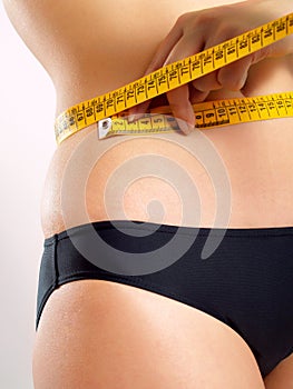 Woman measuring her abdomen photo