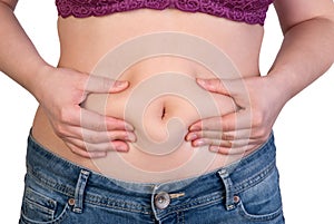 Woman measuring her belly fat