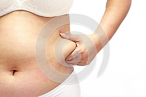 Woman measuring her belly fat with her hands photo