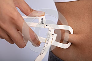 Woman Measuring Her Body Fat With Caliper