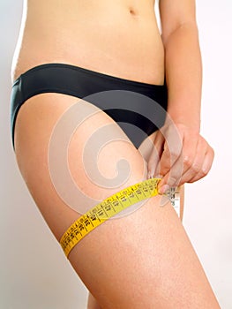 Woman measuring her thigh