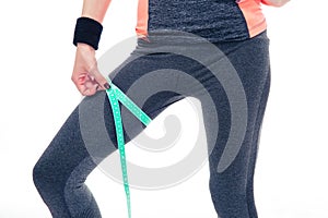 Woman measuring her thigh circumference with tape photo