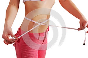 Woman measuring her waist with a measuring tape