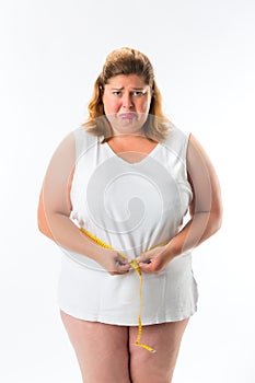 Woman measuring her waist with tape