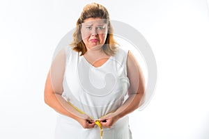 Woman measuring her waist with tape photo