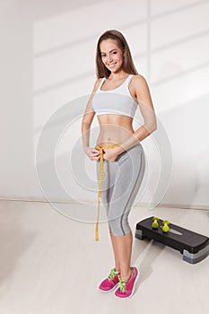Woman measuring her waistline