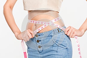 Close Up Woman measuring her waistline with measure line