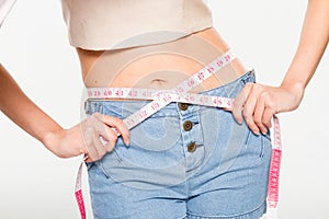 Close Up Woman measuring her waistline with measure line