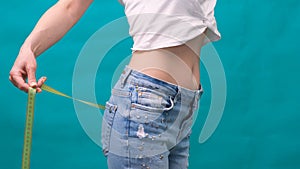 Woman measuring her waistline. Perfect Slim Body. You can get the same results. Close-up of a woman measures her waist