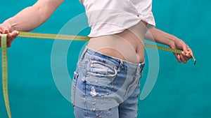 Woman measuring her waistline. Perfect Slim Body. You can get the same results. Close-up of a woman measures her waist