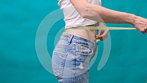 Woman measuring her waistline. Perfect Slim Body. You can get the same results. Close-up of a woman measures her waist