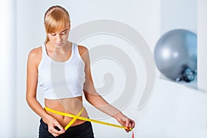 Woman measuring her waistline