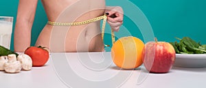 Woman measuring her weist. Diet, healthy eating, food and weigh loss concept.