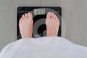 Woman measuring herself on a scale put weight