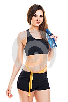 Woman measuring perfect shape of beautiful thigh with bottle of