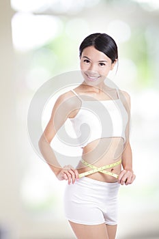 Woman measuring shape of waist with smile