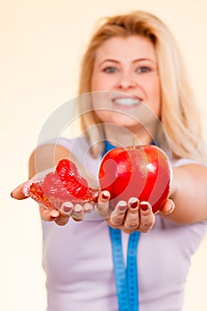 Woman with measuring tape choosing what to eat