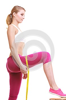 Woman measuring thighs with tape measure. Weight.