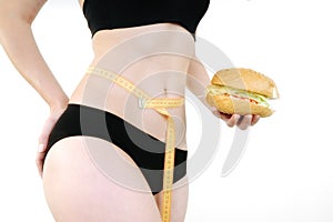 Woman measuring waist measuring tape and hamburger