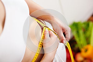 Woman measuring waist with tape