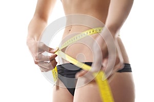Woman measuring waist with tape on white background