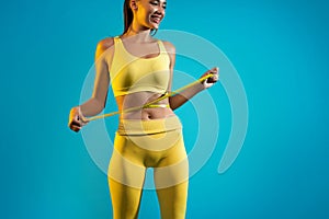 Woman Measuring Waist After Weight Loss, Blue Background, Cropped