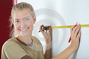 woman measuring wall