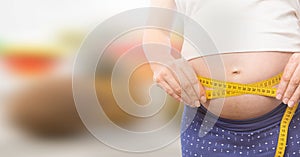 Woman measuring weight with measuring tape on waist on Summer beach