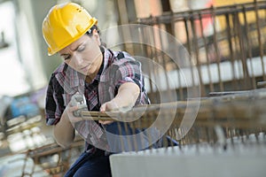 Woman measuring wooden board with tape measure