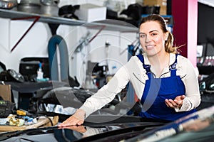 Woman mechanic demonstrating repainted car