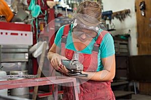 Woman mechanic using an angle grinder
