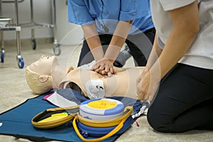 Woman medic demonstrates CPR methods on a plastic mannequin