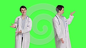 Woman medic does web advertisement against greenscreen backdrop