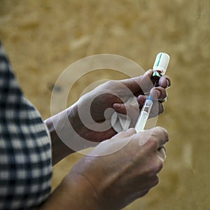 Woman medic opens the vaccine and gaining a syringe for injection. vaccination against dangerous diseases photo