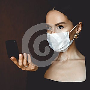 Woman in medical mask looking in mirror