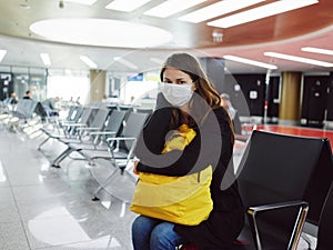 woman in medical mask with luggage airport waiting flight delay