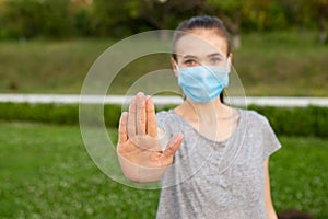 Woman in medical mask show stop gesture by hand