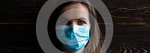 Woman in medical mask on wooden background. Time of quarantine. Coronavirus pandemia. Virus danger infection. Cold or flu