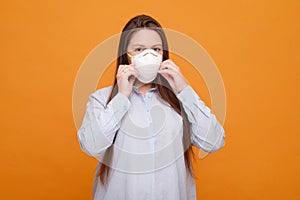 woman in medical mask on a yellow background, coronavirus pandemic