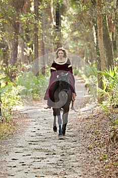 Woman in medieval dress riding horseback