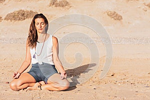 Woman meditating on the beach