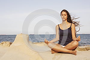 Woman meditating on the beach