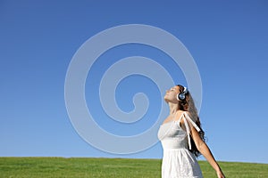 Woman meditating breathing with headphones in nature