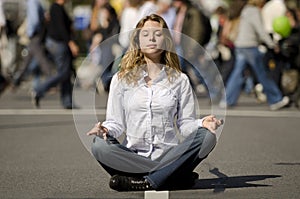 Woman meditating in busy urban street