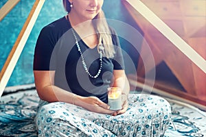 Woman meditating with a candle